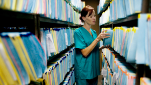 An image showing a room filled with stacks of paper medical records.