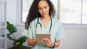 A healthcare professional using a tablet or computer to access patient records.